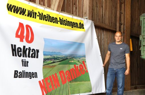 Alexander Stauß von der Bürgerinitiative »Wir bleiben Bisingen« hat in den vergangenen Tagen Plakate aufgehängt, um gegen das interkommunale Gewerbegebiet zu mobilisieren. Foto: Kauffmann