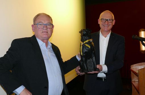 Geschäftsführer Hans Joachim Fischer (links) nimmt von Oberbürgermeister Ralf Broß einen Hörl-Rottweiler entgegen. Fürs Foto wurden die Masken, die sonst den ganzen Abend getragen werden mussten, kurz abgesetzt. Foto: Otto