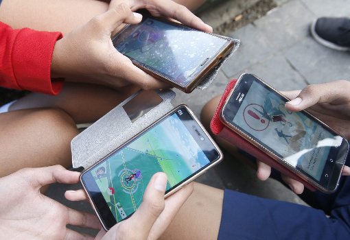 Jugendliche jagen Pokémon mit ihren Smartphones. Foto: Nagi