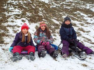 Michelle (von links), Anastasia und Naliah wünschen sich mehr Schnee zum Rodeln. Foto: Röseler