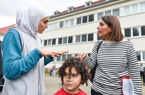 Die baden-württembergische Integrationsministerin Bilkay Öney (rechts, SPD) im Gespräch mit Flüchtlingen in Heidelberg. Foto: dpa