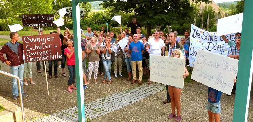 Protest der Owinger vor der Grundschule in Gruol. Am Ende gab Harald Schempp vom Schulamt (Bild unten, rechts daneben Ortsvorsteher Karl-Heinz Binder) Entwarnung. Die neuen Erstklässler bleiben in Owingen.  Foto: Kost