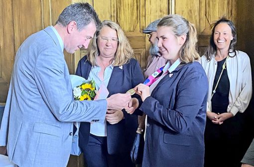 So etwas gibt es nicht alle Tage zu sehen: Oberbürgermeister Erik Pauly bewundert die Goldmedaille von Sophie Kistenbrügger. In der Mitte ihre Mutter Barbara. Foto: Hannah Schedler