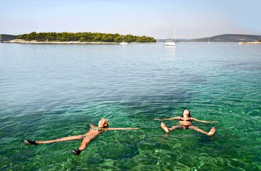 Urlauberinnen lassen es sich in der Adria gut gehen. Derzeit ist das Wasser an manchen Stellen bis zu 30 Grad warm. Foto: imago//Alenmax