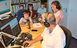 Bastian macht mit Kopfhörer und Mikro beim Kinderferienprogramm unter Anleitung von Radio-Macher Harald Schneider seine erste Ansage.  Foto: Bolkart Foto: Schwarzwälder-Bote