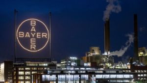 Das Logo des Unternehmens leuchtet auf dem Werksgelände in Leverkusen. Foto: Thomas Banneyer/dpa