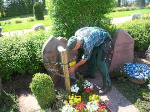 Eberhard Steiniger sichert lose Grabsteine seit diesem Jahr mittels eines Holzpflocks und eines Spanngurts. Foto: Hölle