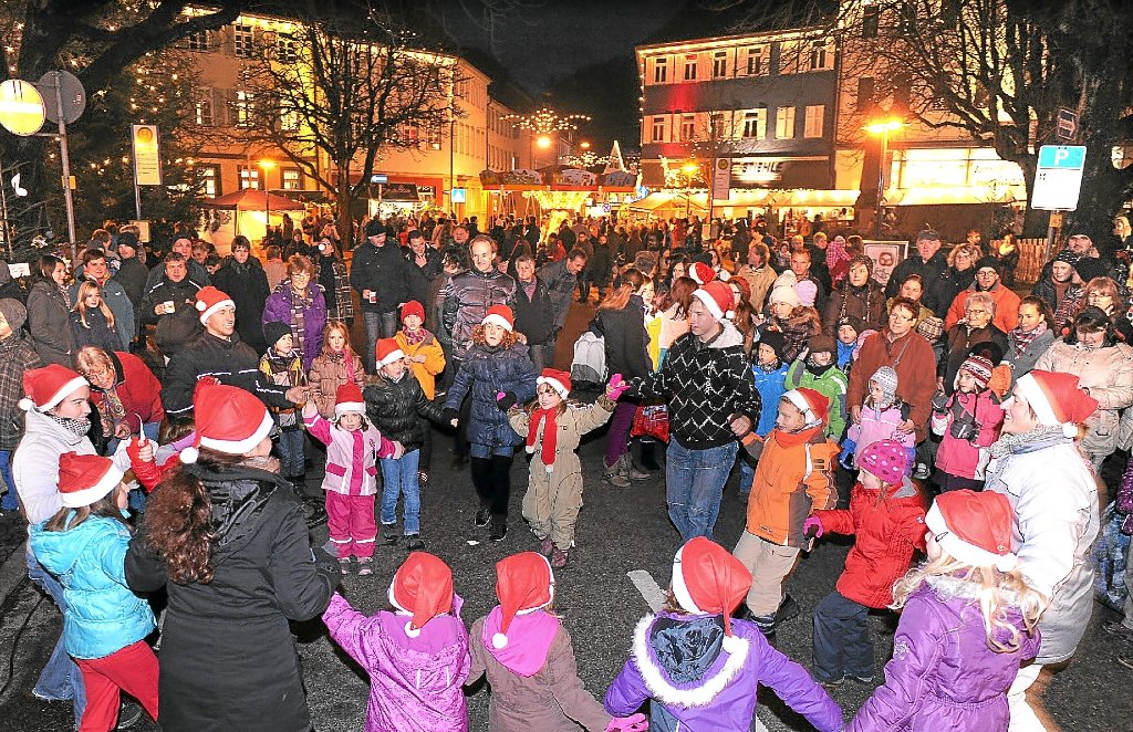 Der Sulzer Marktplatz weihnachtlich beleuchtet: Im Vordergrund zeigen die Kinder der Volkstanzgruppe einen Tanz.
