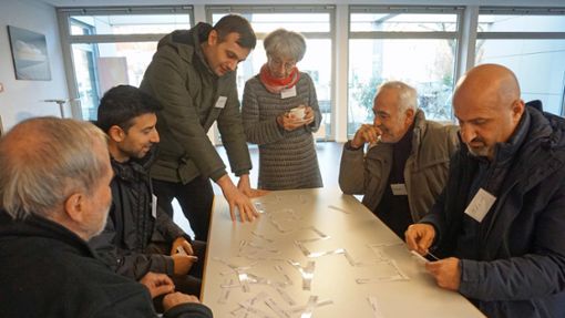 Im Café probieren Einheimische und Migranten ein selbstgemachtes Domino aus, mit dem man deutsche Sätze bilden kann. Foto: Freundeskreis Flüchtlinge