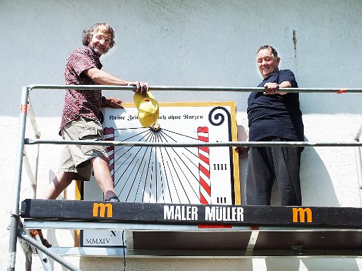 Yves Opizzo (links) und Malermeister Willi Haasis sind fast fertig: Am Montag wird die restaurierte Sonnenuhr eingeweiht.  Foto: Archiv Foto: Kistner