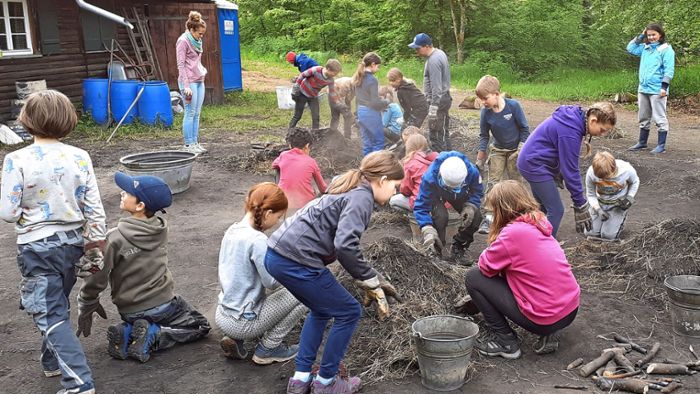 Kinder entfachen eigenes Feuer für Holzkohle