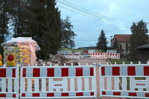 Immer noch dicht ist die Brändbachbrücke in Waldhausen (links). Nicht immer herrscht Betrieb auf der Baustelle (rechts), weil unter anderem  die Baustoffe aushärten müssen. Das ärgert viele Anlieger. Foto: Rademacher