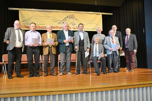 Präsident Michael Ashcroft (links) hat unter anderem neun Männer ausgezeichnet, die bereits seit 65 Jahren in ihrem jeweiligen Heimatverein singen. Foto: Dürrschnabel Foto: Schwarzwälder Bote