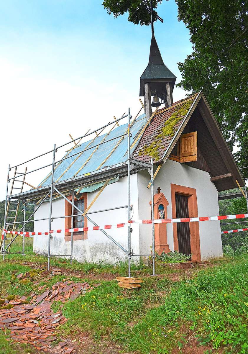 Ein Blitz hat das Dach der Hugenhofkapelle in Schuttertal zerstört: Unzählige rote Ziegel wurden durch den Einschlag  auf die Wiese  neben dem Gebäude geschleudert. Foto: Dach