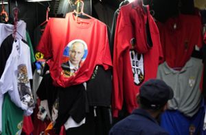 Ein Mann betrachtet in Belgrad ein T-Shirt mit Putin-Aufnäher. Foto: dpa/Darko Vojinovic