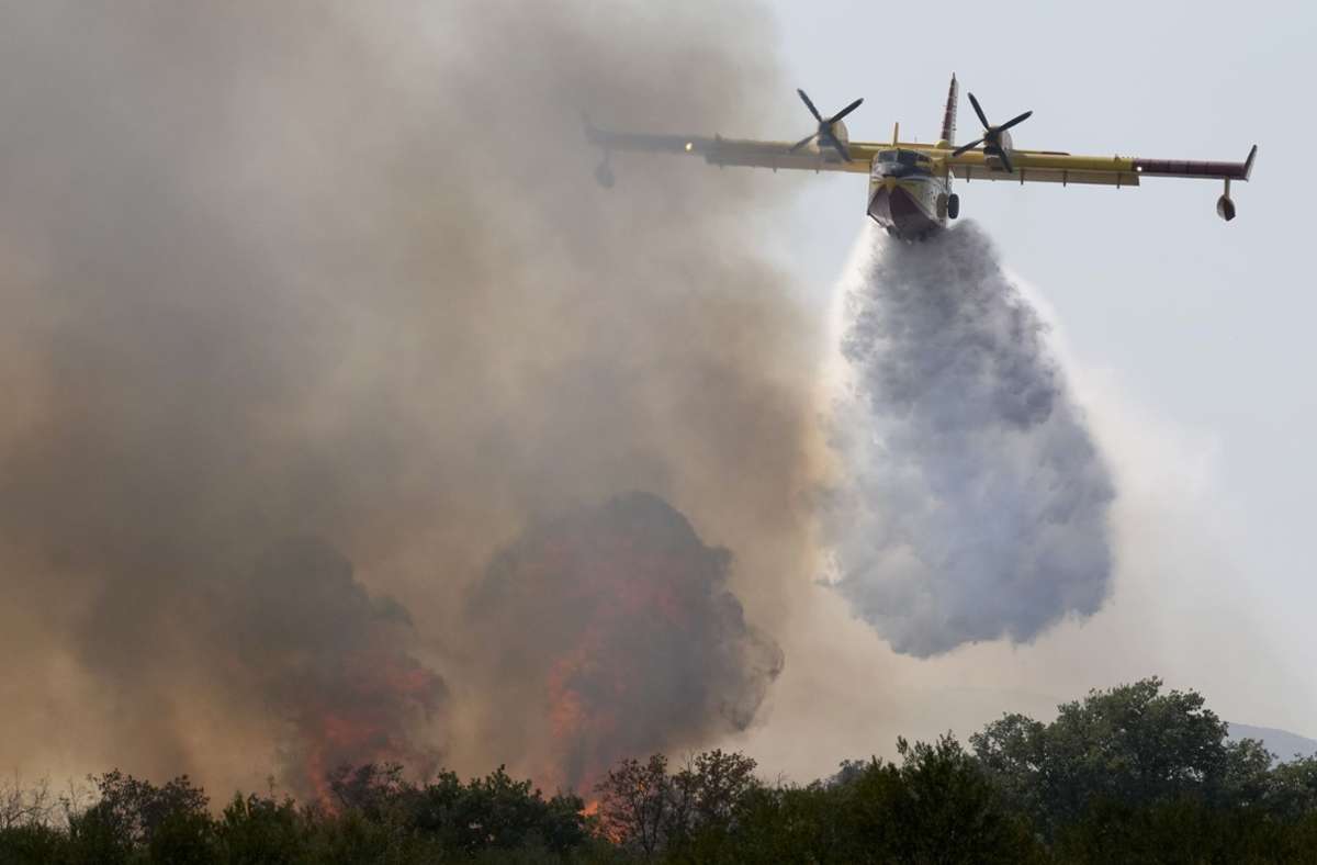 Ein Löschflugzeug wirft Wasser aus der Adria über einem Waldbrand in der Nähe von Biograd ab. Foto: Darko Bandic/AP/dp/a
