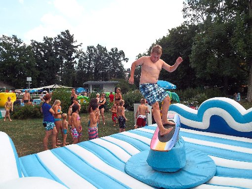Auf einem Hindernisparcours im Wasser, einer Hüpfburg oder beim Rodeo Surf Riding vergnügen sich die jungen Besucher bei der Pool-Party im Geislinger Schlossparkbad. Foto: Schnurr
