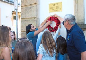Eine Gruppe Jugendlicher aus dem Jugendtreff Dillweißen-stein brachte an der Gedenktafel für den ermordeten Fliegeroffizier James Vinell einen neuen Kranz aus Klatschmohnblüten an.  Foto: Helbig Foto: Schwarzwälder Bote