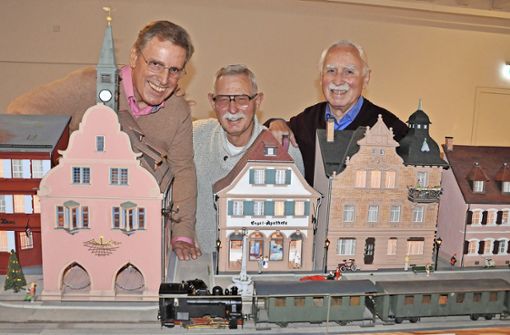 Rolf Ilzhöfer (von links), Werner Friedemann und Otto Krämer haben das Alte Rathaus und andere historische Gebäude am Urteilsplatz nachgebaut. Das „Bähnli“ mit Dampflok und Personenwagen komplettiert das Ensemble. Foto: Schabel