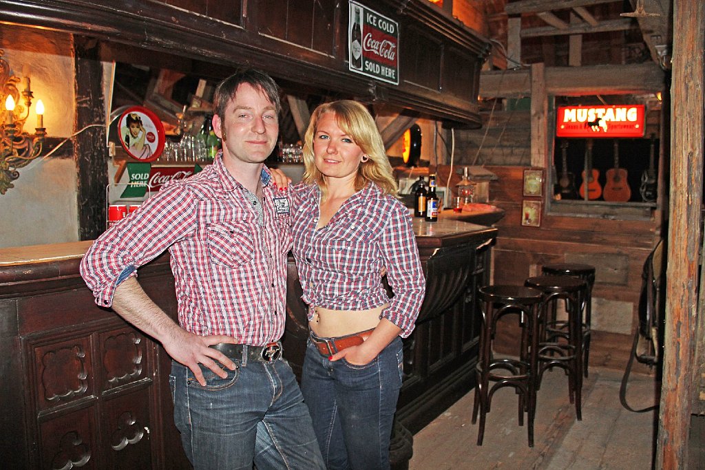 Das Cowboy-Flair ist einfach toll: Jessica und Jens Wilde in ihrer Western-Bar vor der alten Sonnen-Theke.