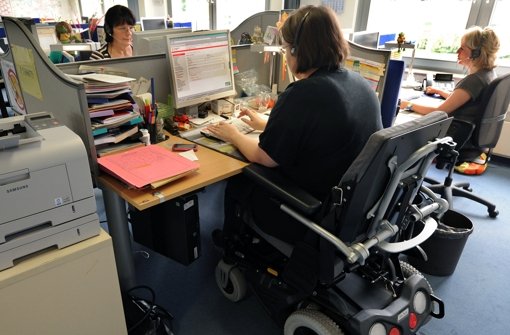 Eine im Rollstuhl sitzende Frau arbeitet als Telefonserviceberater in einem Call-Center.  Schwerbehinderte konnten vom anhaltend positiven Trend auf dem Arbeitsmarkt bisher nicht profitieren. Foto: dpa