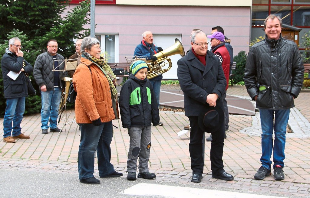 Bei der Eröffnung des Alpirsbacher Weihnachtsmarkts: Maria Klink (vorne links), Bürgermeister Reiner Ullrich (vorne, Zweiter von rechts) und HGV-Vorsitzender Georg Steinberger (rechts) vor den Alpirsbacher Musikfreunden