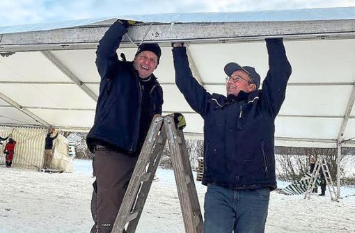 Klemens Krause-Sittnick (links) und Berthold Götz hängen beim Aufbau neben der Baarblickhalle eine Zeltplane ein. Foto: Vetter