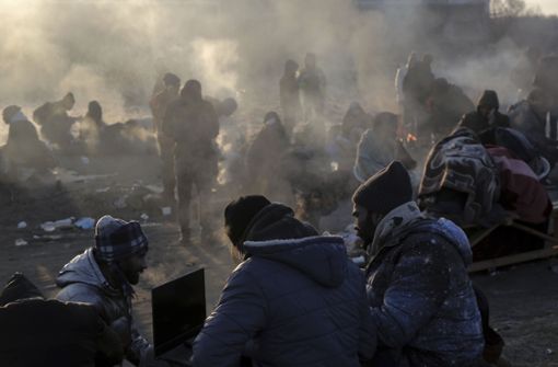 Flüchtlinge, die vor dem russischen Angriff auf die Ukraine geflohen sind, versuchen sich am Grenzübergang Medyka warmzuhalten. Foto: dpa/Visar Kryeziu