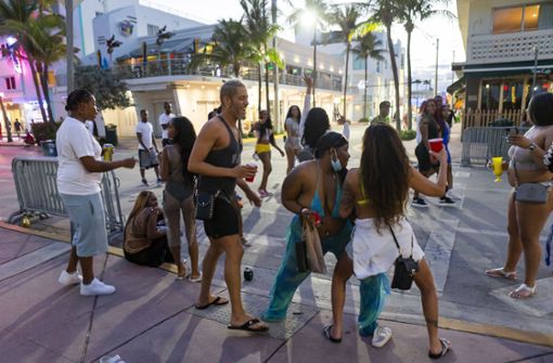 Eine Gruppe von Touristen tanzt auf dem Ocean Drive während des Spring Break in Miami Beach. In Miami Beach ist eine Ausgangssperre in Kraft, die verhängt wurde, nachdem es zu Schlägereien, Schießereien, Sachbeschädigungen und gefährlichen Ausschreitungen in großen Menschenmengen gekommen war. Foto: dpa/Matias J. Ocner