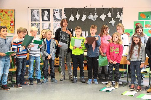 Die Mühlheimner Grundschüler singen mit ihrer Lehrerin ein Gepensterlied. Im Hintergrund hängen Spukbilder und Gespenstermarionetten. Foto: Steinmetz Foto: Schwarzwälder-Bote