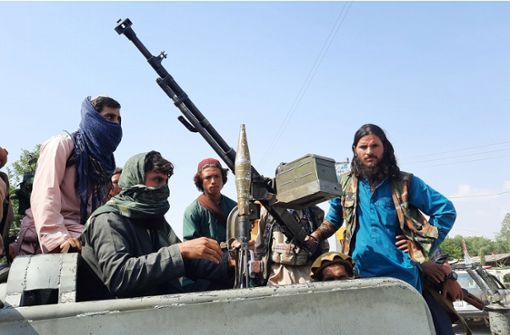 Schwer bewaffnete Taliban-Kämpfer fahren in einem Fahrzeug durch Mehtarlam, die Hauptstadt der Provinz Laghman in Afghanistan. Foto: dpa/Str