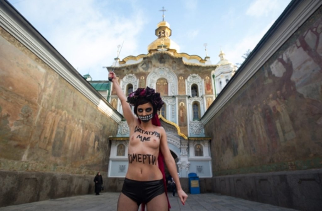 Trotz klirrender Kälte hat eine Femen-Aktivistin barbusig gegen Janukowitsch protestiert. „Tod der Diktatur“ stand auf ihrem Oberkörper. Foto: dpa