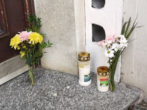 Betroffenheit nach der schrecklichen Bluttat: Am Eingang des Hauses erinnern Blumen und Kerzen daran.  Foto: Eyrich