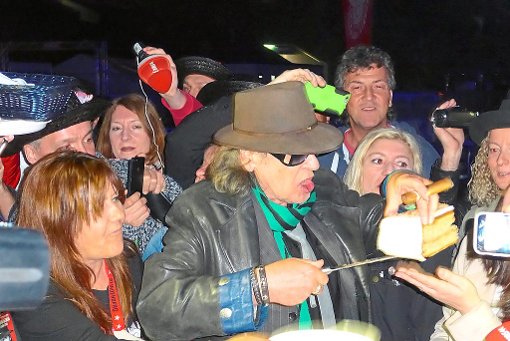 Mit Hut, Sonnenbrille und Zigarre: Udo Lindenberg verteilt die Geburtstagstorte an seine Fans.  Foto: Privat
