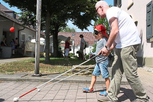 Mal wissen, wie man sich als Blinder fühlt: Der sechsjährige Ben will  an der Hand von Harald Frase herausfinden, wie man sich mit einem Blindenstock in der Stadt zurechtfindet.    Fotos: Thiercy Foto: Schwarzwälder-Bote
