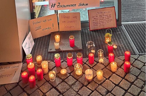 Plakate und Kerzen legten die Teilnehmer vor der Praxis ab. Foto: Müller