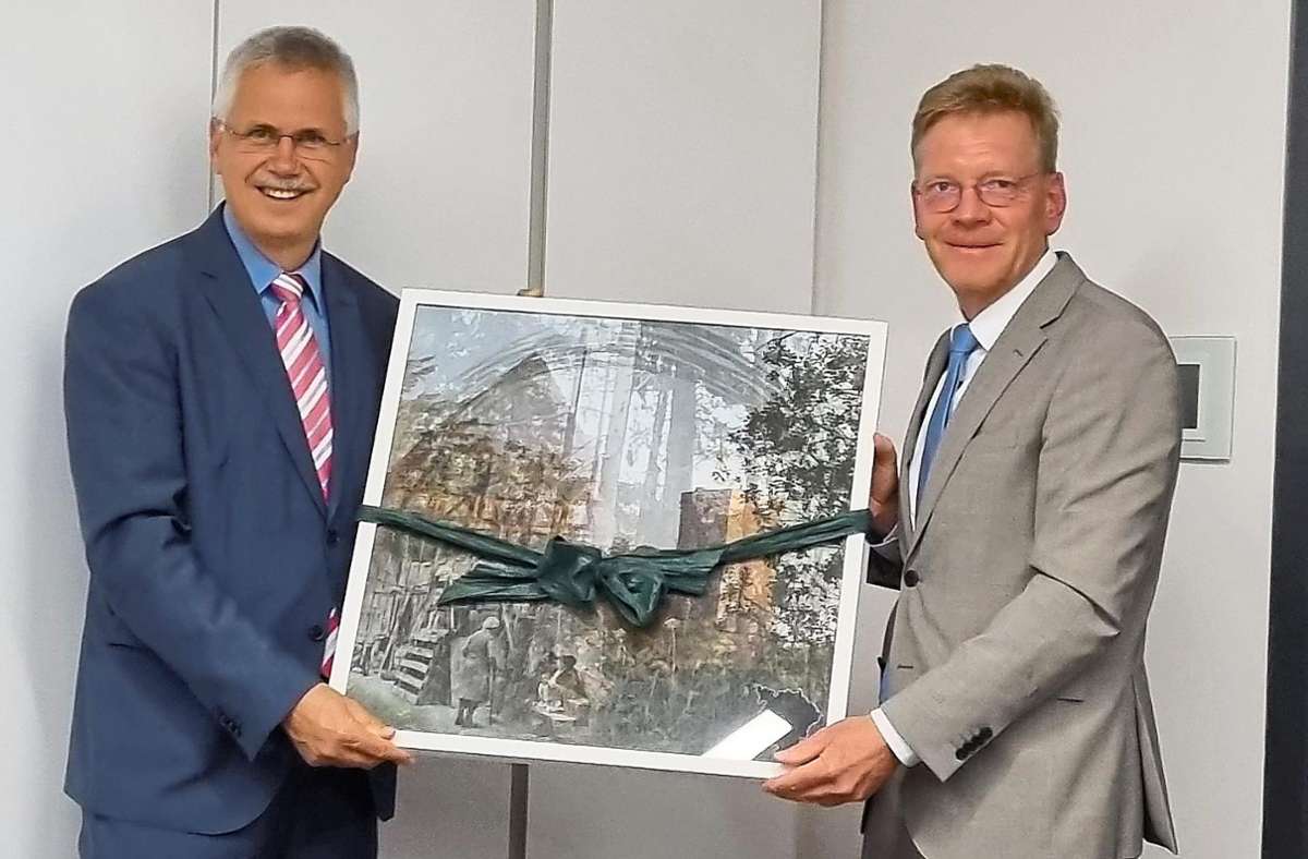 Als Präsent zum 40-jährigen Dienstjubiläum erhält Bürgermeister Jens Häußler (links) aus den Händen von Landrat-Stellvertreter Frank Wiehe eine gerahmte Grafik aus der neuesten Grafik-Edition des Landkreises. Foto: Tröger