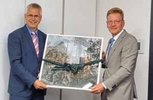 Als Präsent zum 40-jährigen Dienstjubiläum erhält Bürgermeister Jens Häußler (links) aus den Händen von Landrat-Stellvertreter Frank Wiehe eine gerahmte Grafik aus der neuesten Grafik-Edition des Landkreises. Foto: Tröger