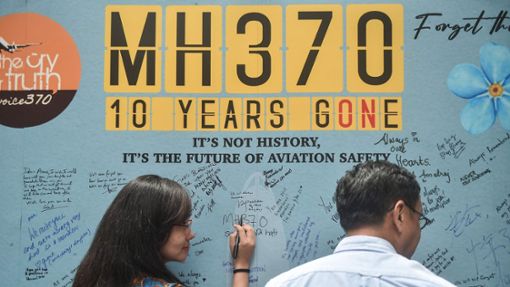 Angehörige von Insassen der verschwundenen Maschine schreiben bei einer Veranstaltung zum zehnten Jahrestag auf eine Tafel. Foto: AFP/Arif Kartono