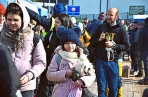 Dieses Mädchen trägt ihren Hund über den polnisch-ukrainischen Grenzübergang Medyka –  in Sicherheit, aber auch in eine ungewisse Zukunft. Foto: Spitz