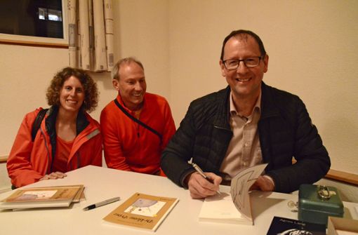 Gute Laune bei der Buchsignierung: Mundartpfarrer Manfred Mergel (rechts) freut sich mit zwei Besuchern über eine gelungene Lesung. Foto: Lothar Schwark