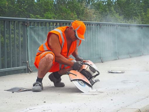 Ein Bauarbeiter entfernt die Halterungen für die ehemalige Leitplanke, die versetzt werden muss. Foto: Schwarzwälder Bote