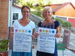 Regina Martini (links) und Carla Dikkers präsentieren bei der Jubiläumsfeier in der Schenke & mehr die Plakate, auf die die Waldachtaler vor fünf Jahren ihre Wünsche an einen Bürgertreff niedergeschrieben haben. Foto: Begemann Foto: Schwarzwälder Bote
