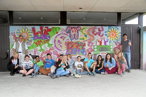 Die Achtklässler der Albert-Schweitzer-Schule machten zusammen mit Mitgliedern der Kunstakademie U7 aus der grauen Betonwand an der Schule ein buntes Graffiti-Kunstwerk. Foto: Wahl
