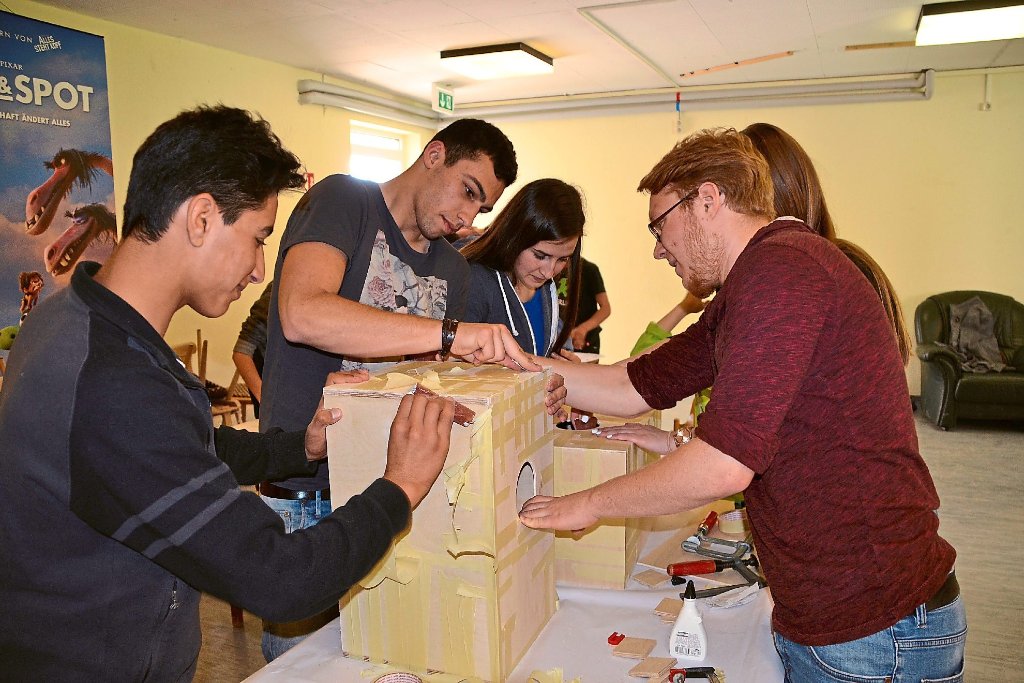 Deutsche und ausländische Jugendliche bauen gemeinsam Kistentrommeln im Jugendraum der Flüchtlingsstelle. Fotos: Holbein