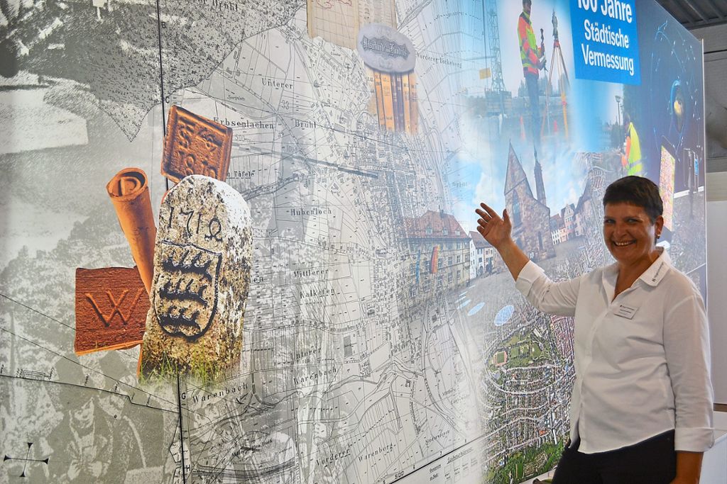 Alexandra Seifried vom städtischen Vermessungsamt erläutert an der großen Wand am Stand der Stadt die Entwicklung der Messtechnik. Foto: Streck