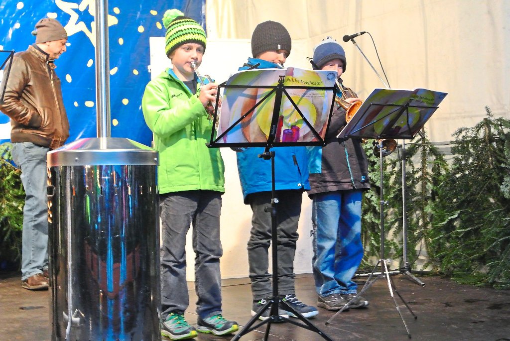 Sie hatten es auf der Bühne wenigstens trocken: Drei jungen Blasmusiker spielten Weihnachtslieder. Fotos: Braun