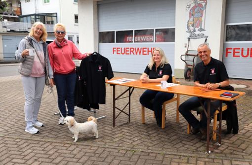 Ortschaftsrätin Sarah Bühner und Ortschaftsrat Volker Hoss verkaufen das Jubiläumsshirt samt Tasse. Foto: Schwind