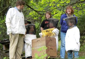Imker Hubert Schwäble klärt Emma, Samuel und Adrian (in Imkerkluft) über die Bienen auf. Justus (im Hintergrund) schaut ebenso interessiert zu. Foto: Kommert Foto: Schwarzwälder-Bote