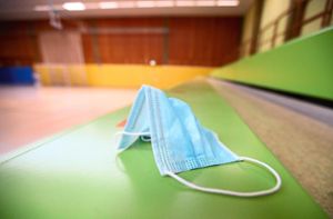 Ein Mund-Nase-Schutz liegt auf der leeren Tribüne einer Sporthalle Foto: Eibner